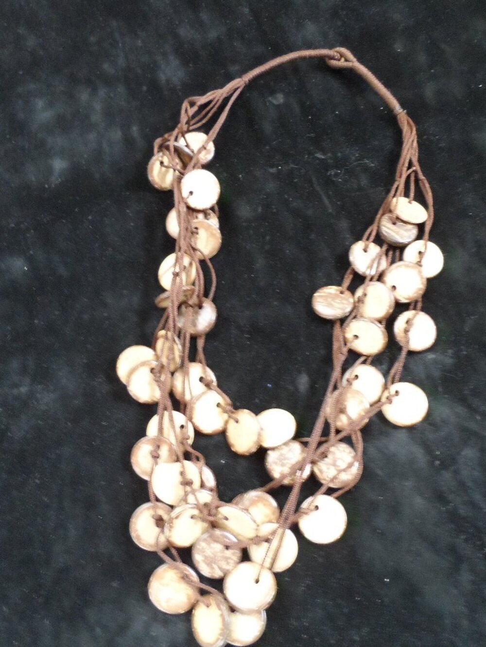 handmade multi-strand necklace features circular shell or coconut wood beads